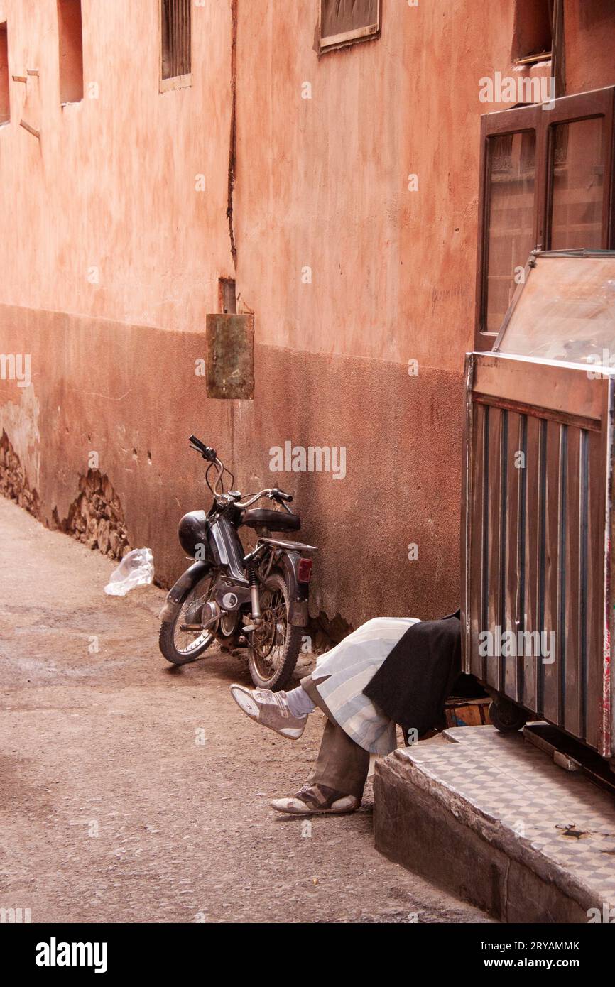 Jambes de repos et vélo garé dans la rue latérale Marrakech au Maroc Mars 2012 Banque D'Images