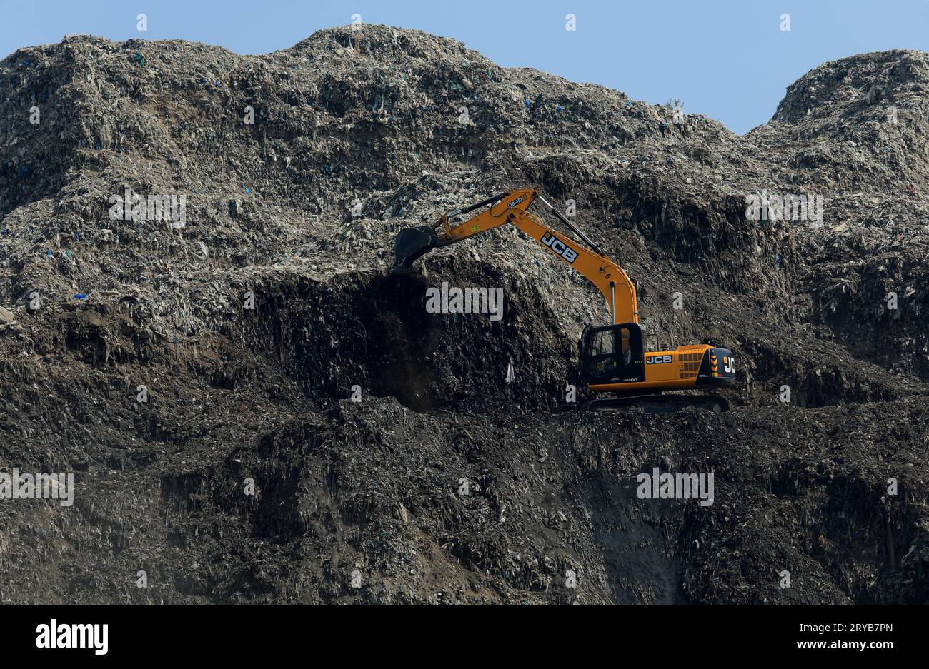 New Delhi, Inde. 30 septembre 2023. Une grue excavatrice JCB soulevant des déchets du site d'enfouissement de Bhalswa à New Delhi. La décharge de Bhalswa est une décharge de déchets surchargée située dans la région du nord-ouest de Delhi. Il mesure plus de 62 mètres (203 pieds) de haut. Le résident local est confronté à la pollution de l'environnement, à des problèmes de santé publique et de sécurité. Crédit : SOPA Images Limited/Alamy Live News Banque D'Images