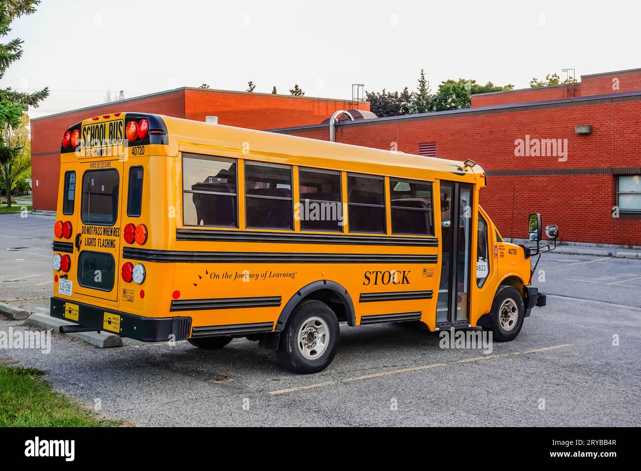 autobus scolaire jaune garé sur un parking scolaire Banque D'Images