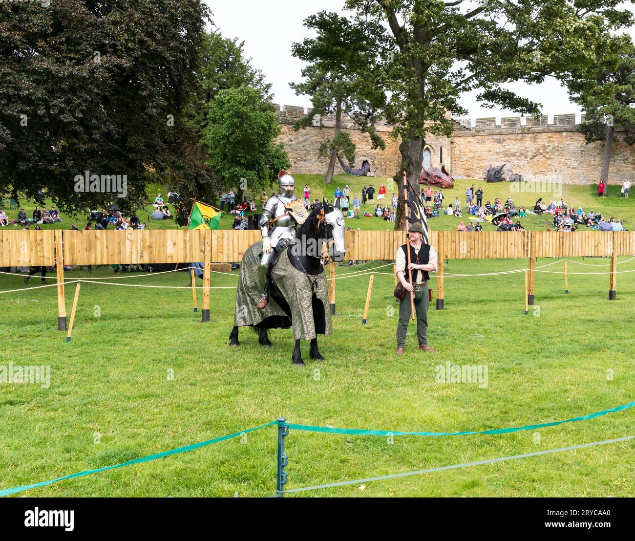 Chevalier à cheval avec écuyer tenant la bannière prenant les applaudissements du public, château de Lincoln, Lincoln City, Lincolnshire, Angleterre, ROYAUME-UNI Banque D'Images