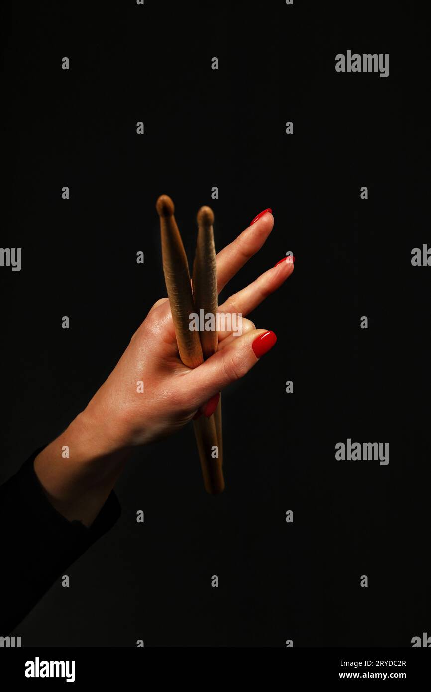 Main de femme avec des pilons, cornes de diable sur noir Banque D'Images