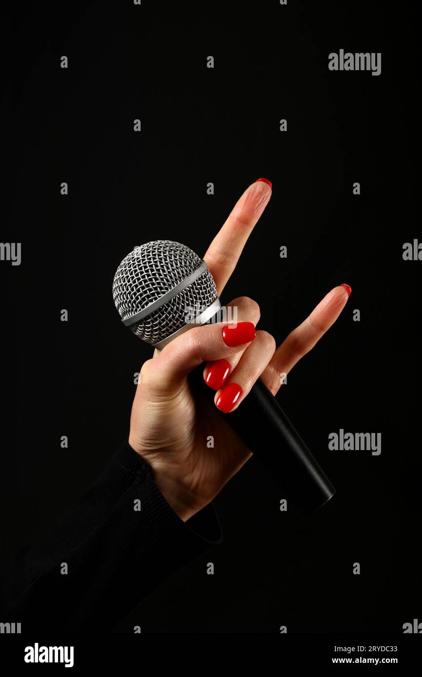 Femme part avec microphone et devil horns isolated on black Banque D'Images