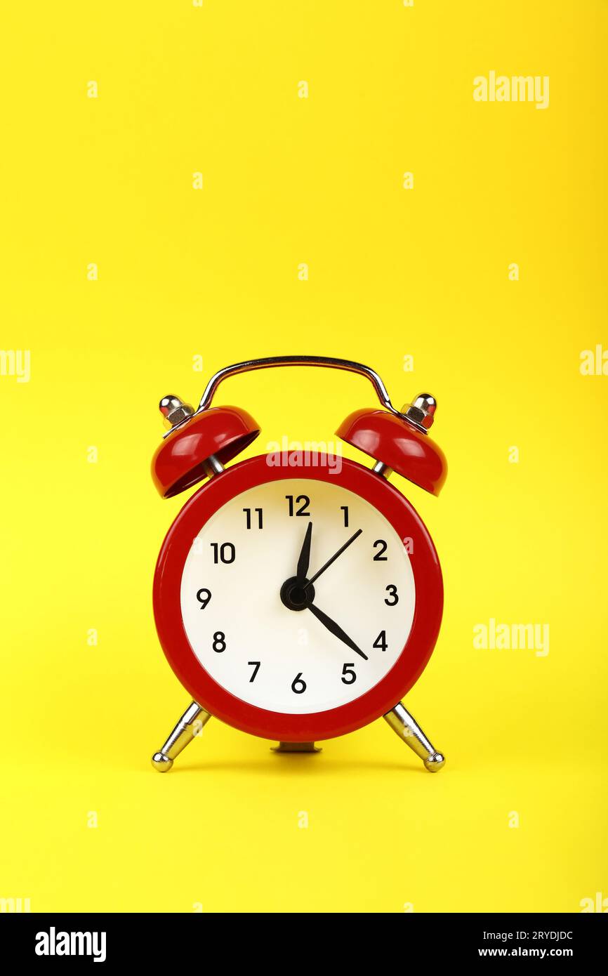 Fermez un réveil rouge sur fond jaune Banque D'Images