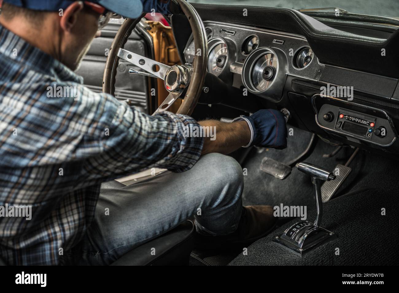 Caucasian Classic Cars Mechanic à l'intérieur de American muscle car. Thème de l'industrie automobile. Banque D'Images