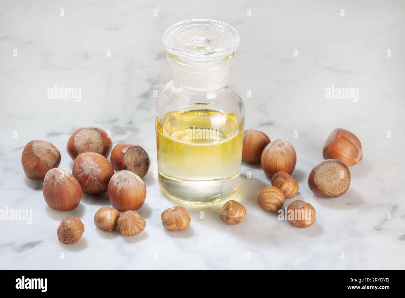 Huile de noisette en bouteille en verre sur table en marbre Banque D'Images