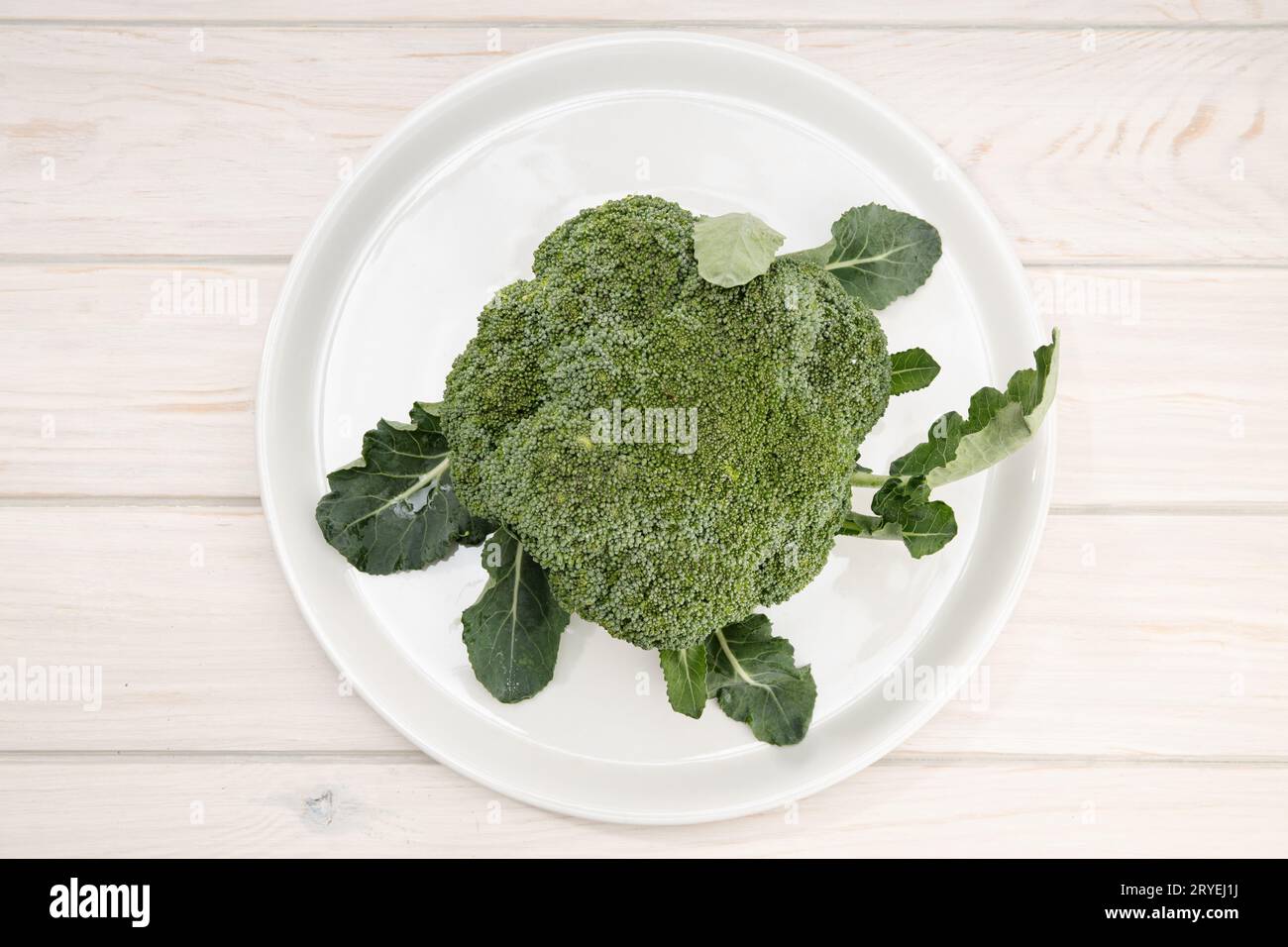 Brocoli frais bio dans une assiette sur une table en bois Banque D'Images