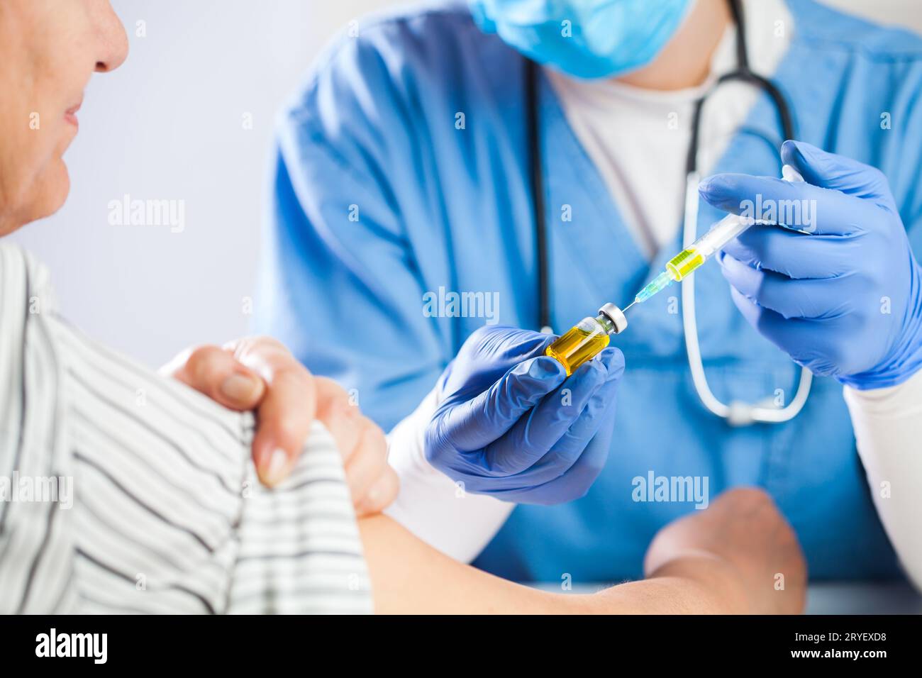 Médecin généraliste féminin tenant le flacon d'ampoule avec le liquide jaune Banque D'Images