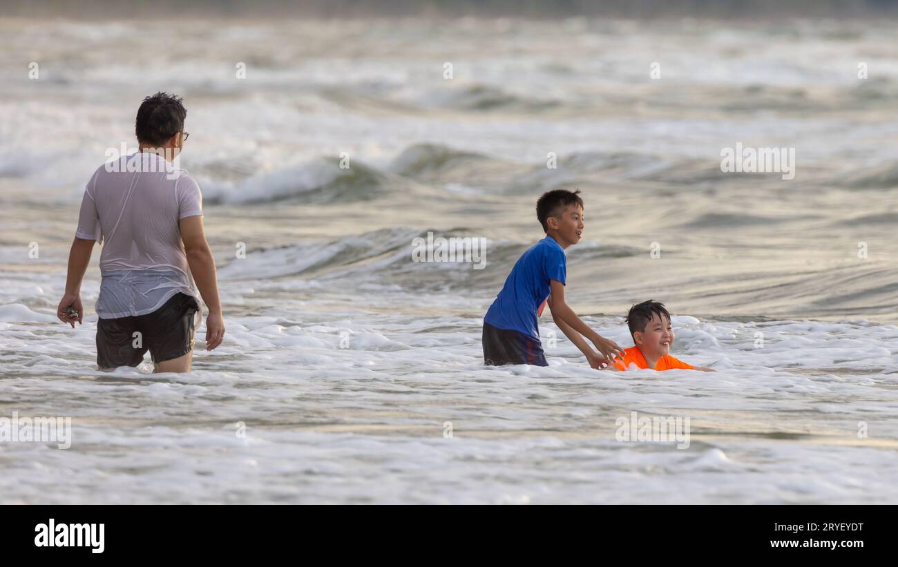 Kota Kinabalu, Sabah, Malaisie- 20 novembre 2021 : visiteur non identifié appréciant et heureux jouant belle et propre plage pendant le coucher du soleil Banque D'Images