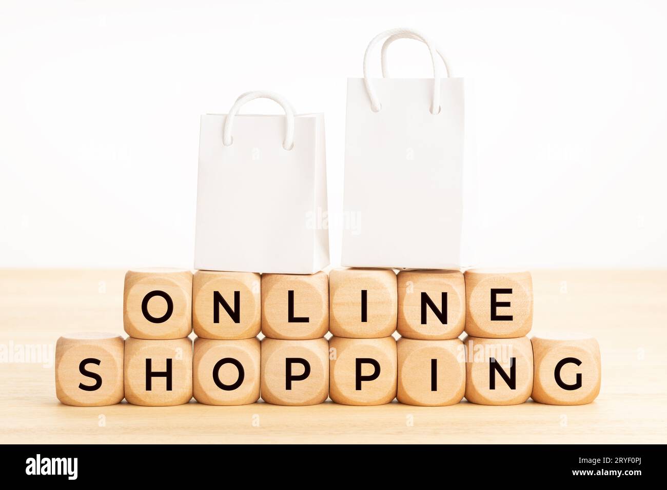 Concept d'achat en ligne. Texte sur les blocs de bois sur la table et les sacs à provisions en papier. Arrière-plan blanc. Copier l'espace Banque D'Images Concept d'achat en ligne. Texte sur les blocs de bois sur la table et les sacs à provisions en papier. Arrière-plan blanc. Copier l'espace Banque D'Images