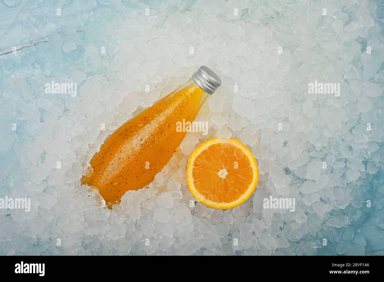 Une bouteille en verre de boisson orange sur glace pilée Banque D'Images