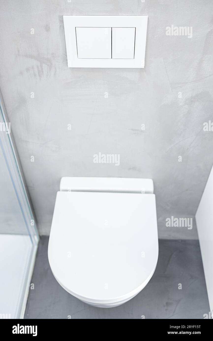 toilettes ou WC fixés au mur ou suspendus dans la salle de bains de la maison avec bouton-poussoir encastré Banque D'Images