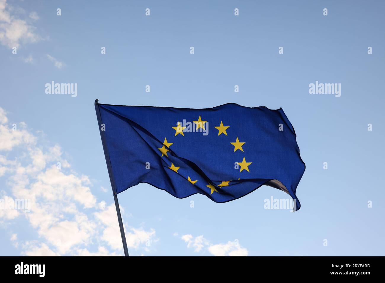 Union européenne drapeau de l'UE volant et agitant dans le vent sur ciel bleu clair, symbole du patriotisme européen, angle bas, vue latérale Banque D'Images