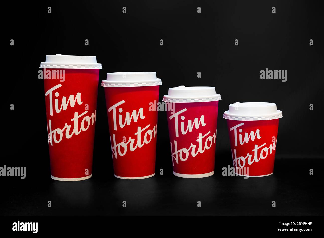 Calgary, Alberta, Canada. 9 avril 2022. Tasses de café Tim Hortons de différentes tailles sur fond noir Banque D'Images