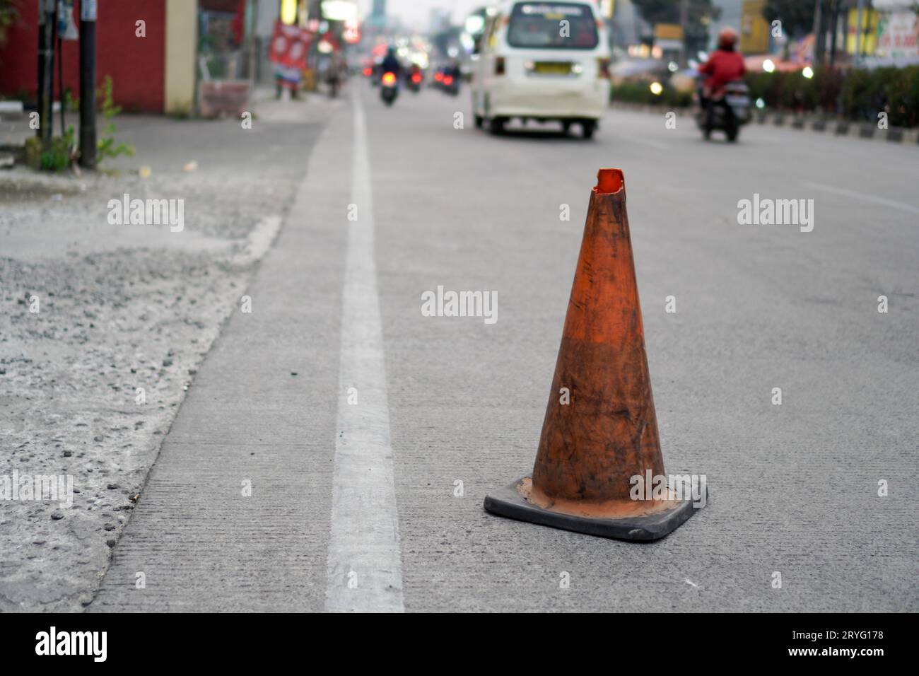 Un barrage orange à côté de la route, un panneau pour quelques nids de poule sur la route. Banque D'Images