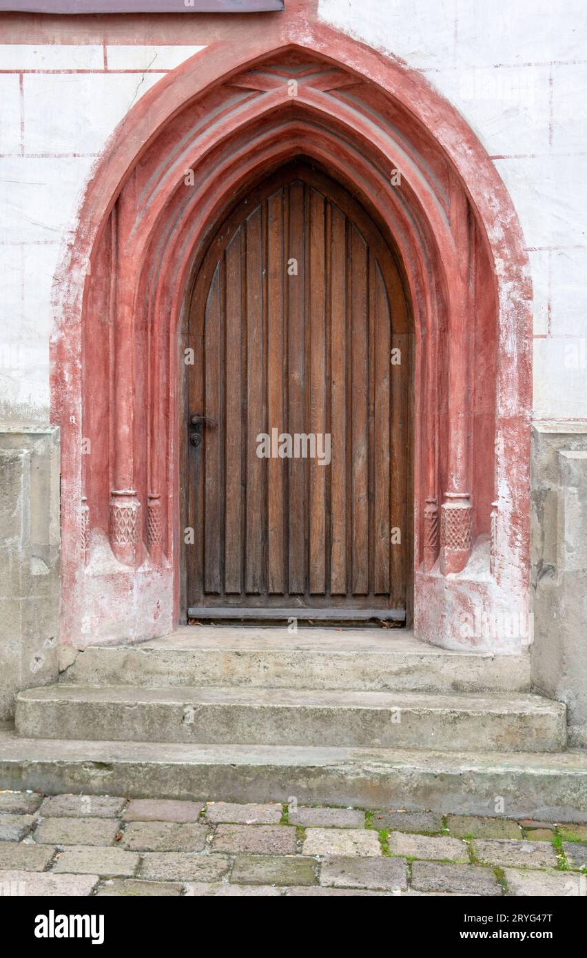 Arquée ancienne porte en bois d'église ancienne dans un mur de pierre. Banque D'Images