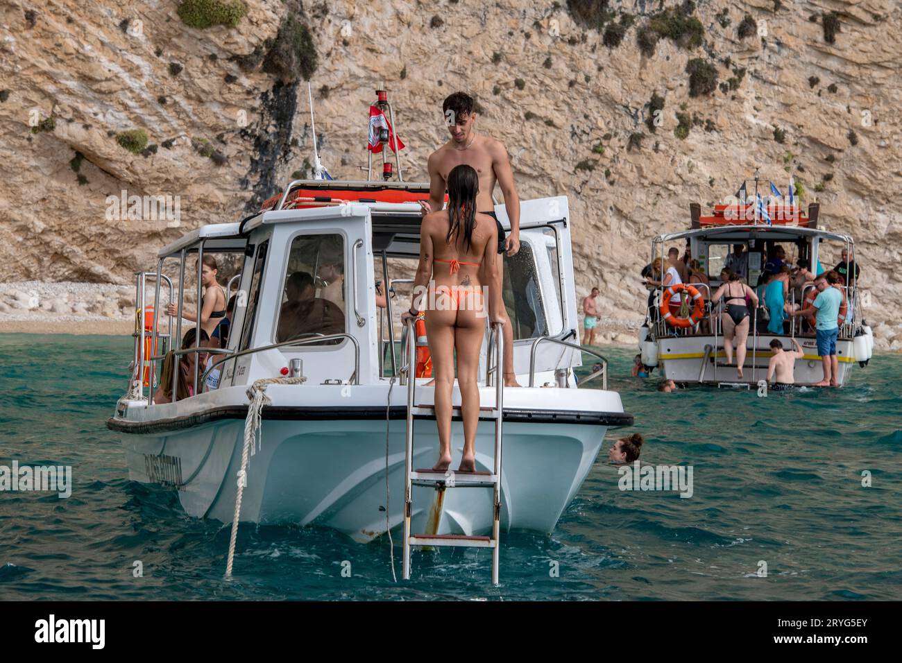 baigneurs ou nageurs sur un petit bateau touristique sur l'île grecque de zante ou zakynthos. femme portant révélant le bikini embarquement bateau de plaisance nageur. Banque D'Images