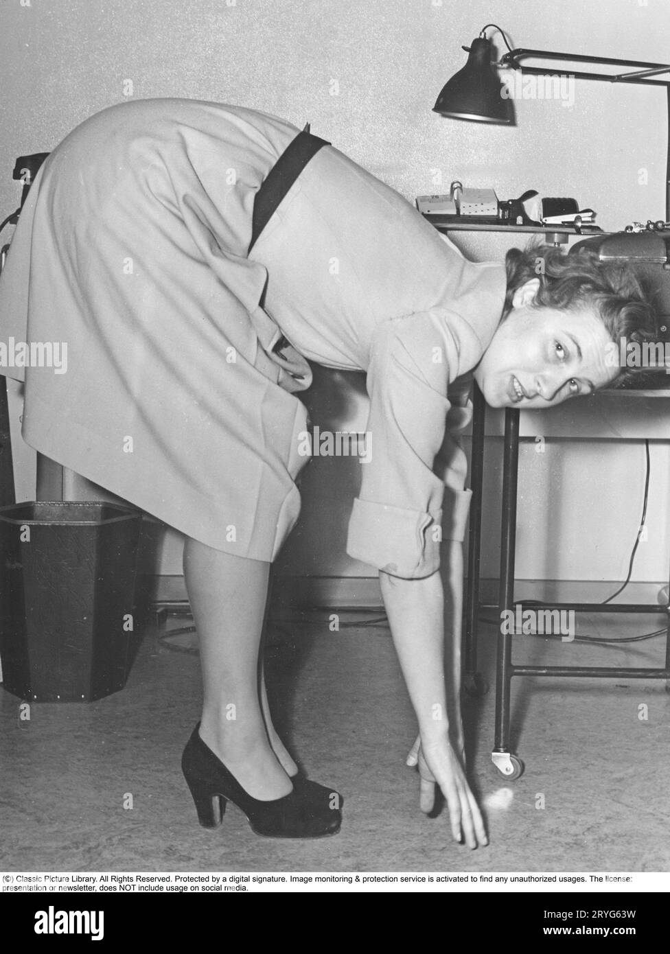 Dans les années 1940 Gymnastique de bureau à la compagnie d'assurance Thulebolagen. Mme Ulla Klingström, employée de l'entreprise, prend une pause et fait de la gymnastique pendant les heures de travail. La gymnastique de bureau était une invention moderne à la fin des années 1940, lorsque les soins de santé pour les employés ont commencé à être mis en œuvre. Suède 1949. Kristoffersson Banque D'Images