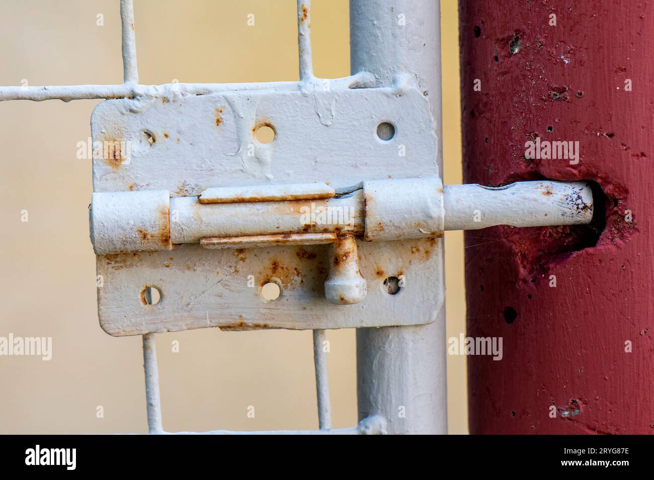 vieux boulon de porte rouillé avec trou dans le mur pour accueillir le boulon. Banque D'Images