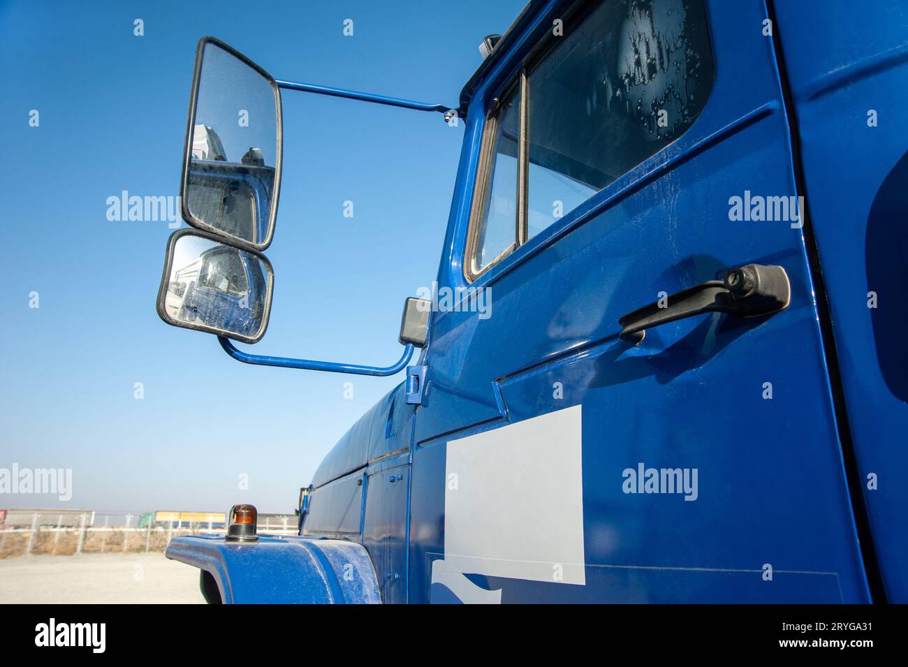 Gros plan d'une porte bleue de camion à benne basculante avec rétroviseur sur un chantier de construction Banque D'Images