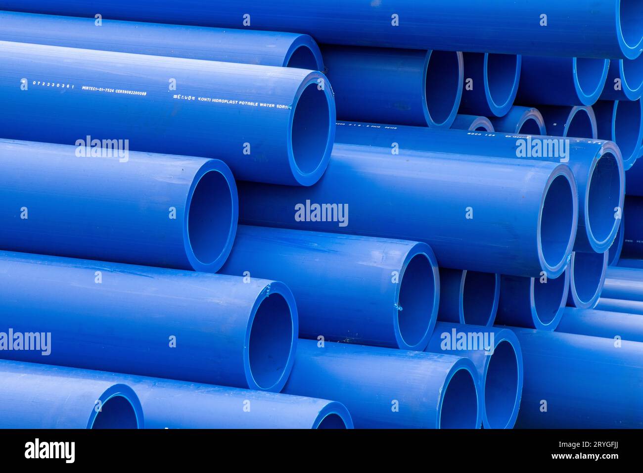gros plan abstrait de tuyaux de drainage ou d'irrigation en plastique de couleur bleue empilés sur un chantier de construction prêts à l'emploi. Banque D'Images