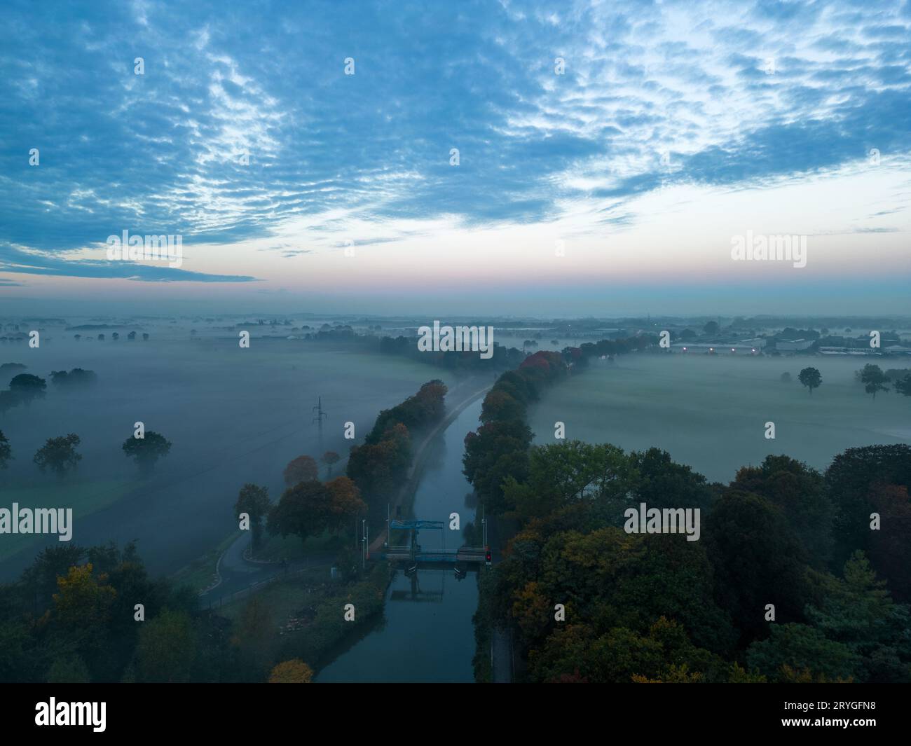 Vue aérienne des arbres brumeux dans le champ au lever du soleil coloré en automne. Paysage coloré avec forêt dans les nuages bas, rivière, prairie i Banque D'Images