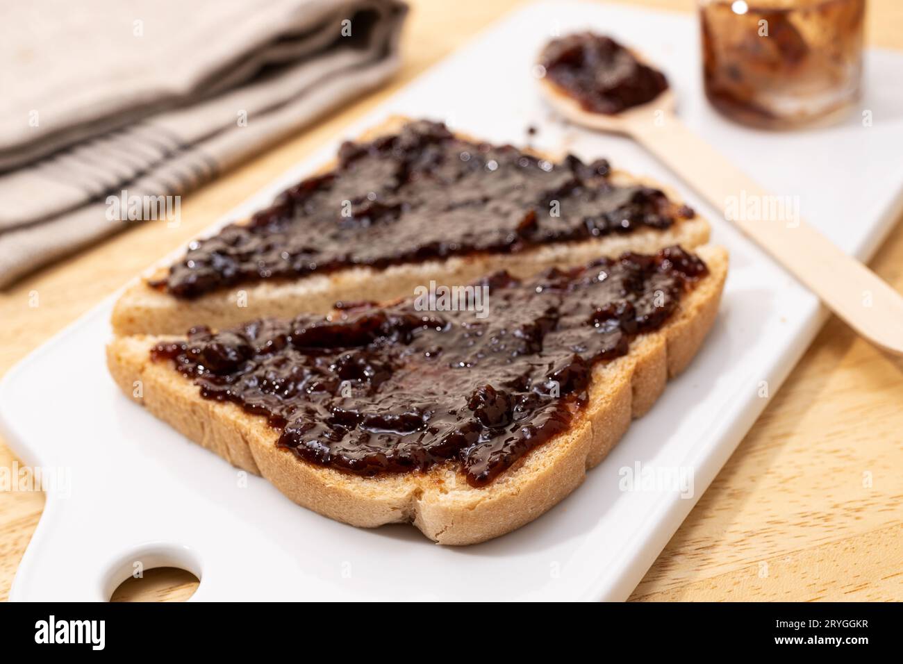 Pain blanc pain grillé sandwich et confiture biologique framboise sur table en bois Banque D'Images