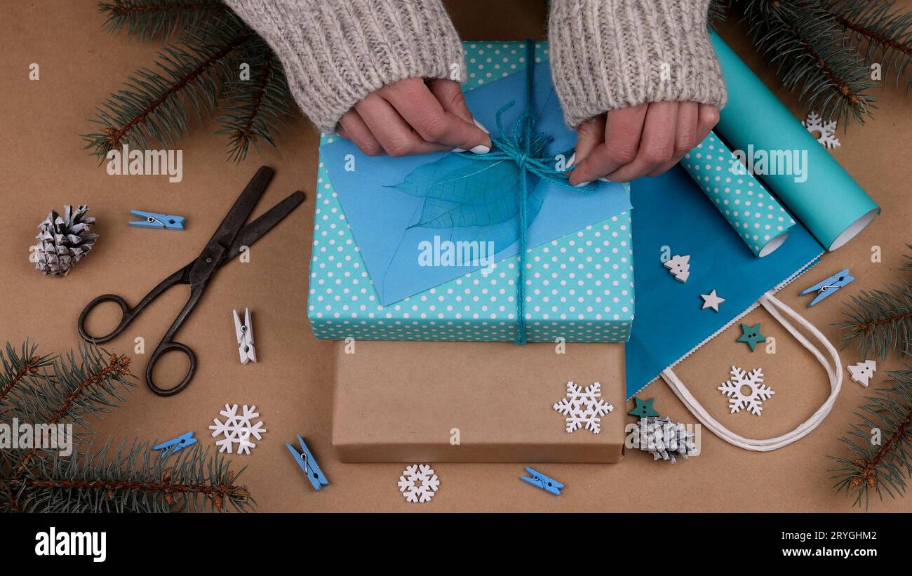 Femme emballant des cadeaux de Noël avec du papier bleu Banque D'Images