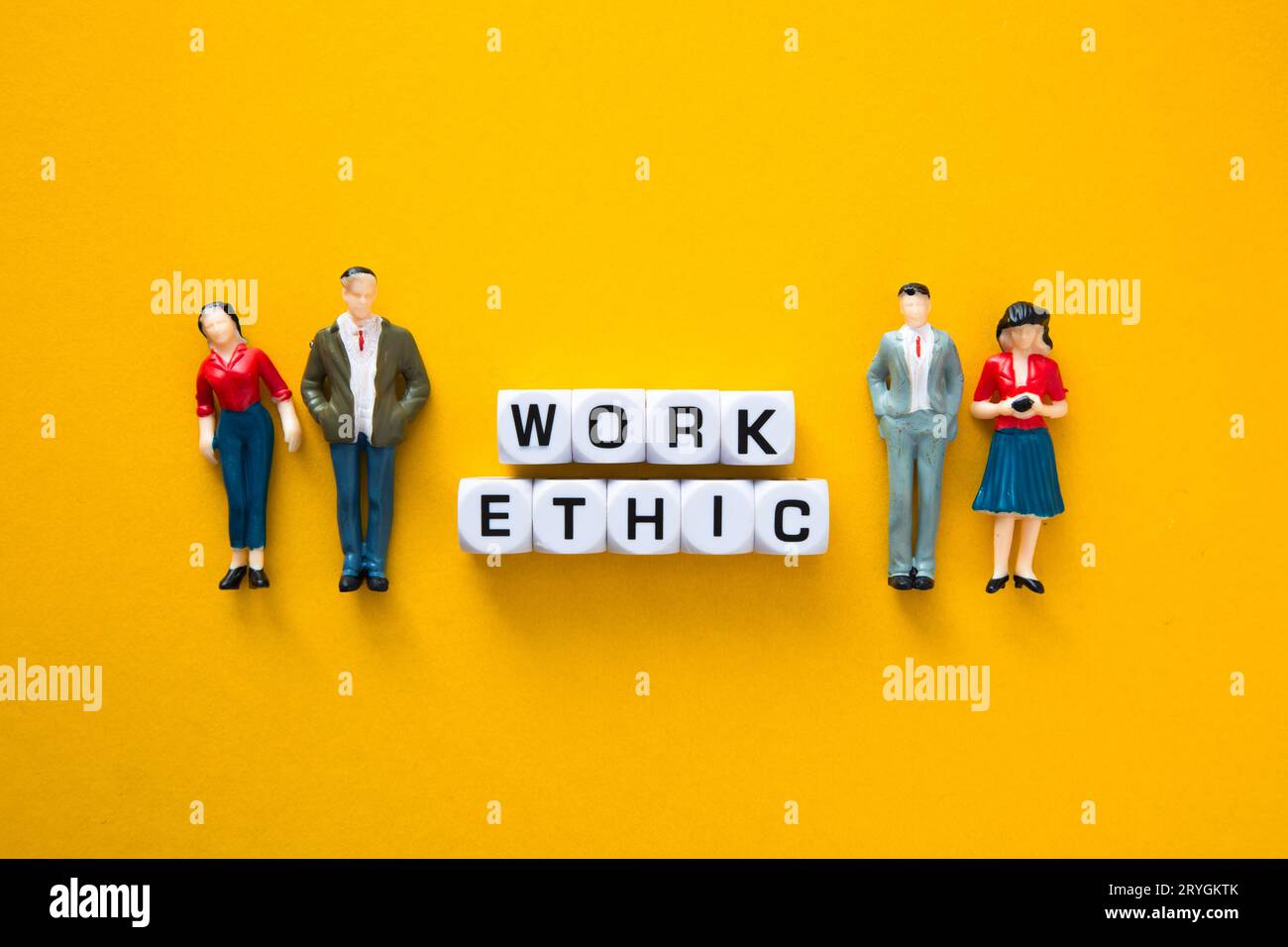 Figurine miniature avec des mots d'éthique de travail sur fond jaune. Éthique Business concept Banque D'Images
