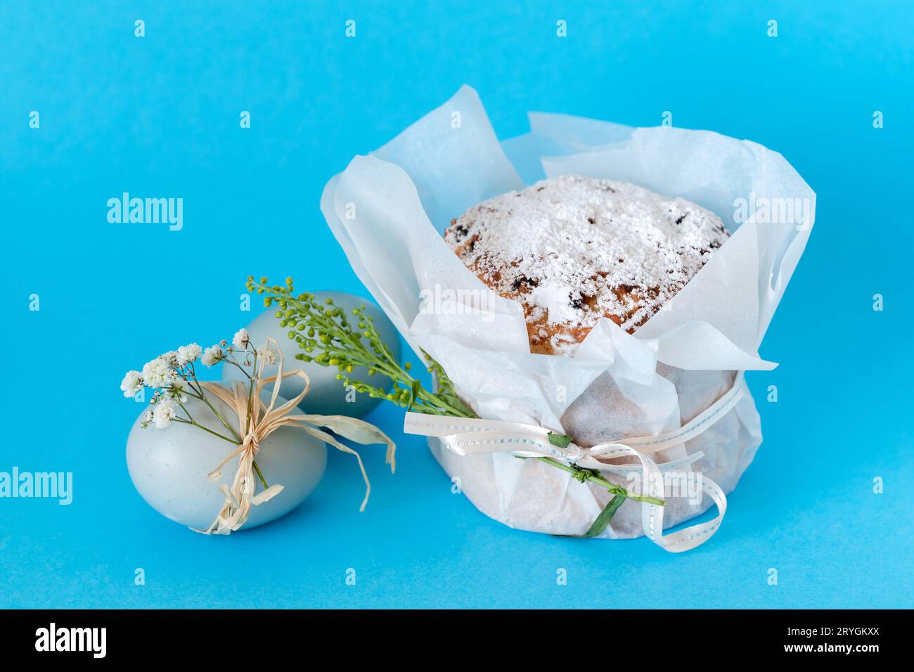 Gâteau de Pâques traditionnel, oeuf coloré avec fleur sur fond bleu Banque D'Images