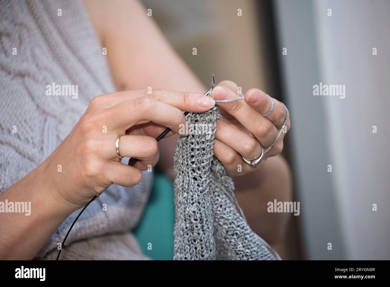Femme tricotant dans le cadre de son travail dans le ménage Banque D'Images