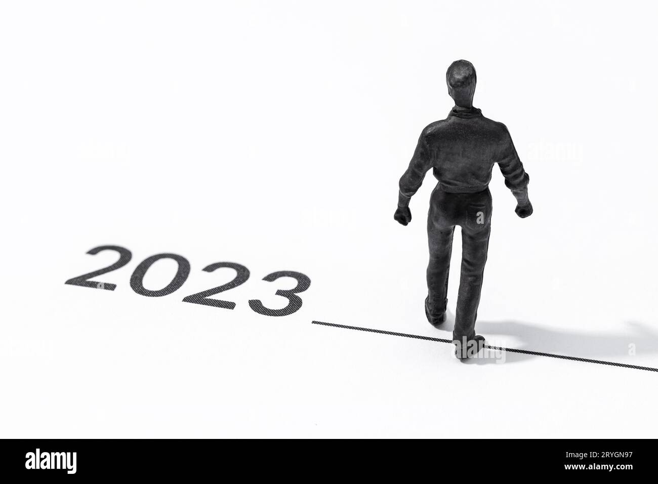 Figurine humaine marchant sur la ligne de départ de l'année 2023 Banque D'Images