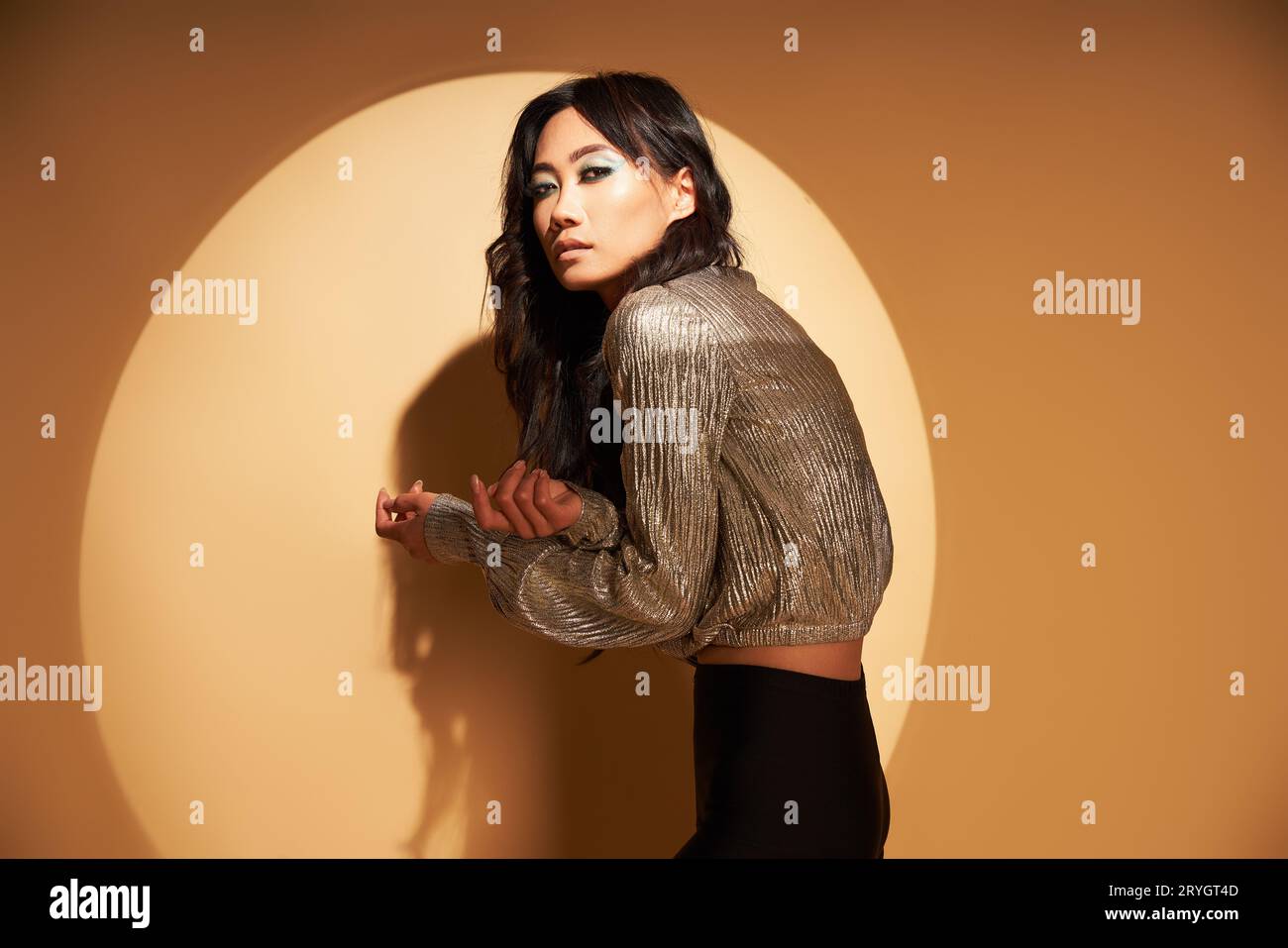 Portrait de style Vogue de femme asiatique sensuelle posant en studio à la lumière du spot Banque D'Images