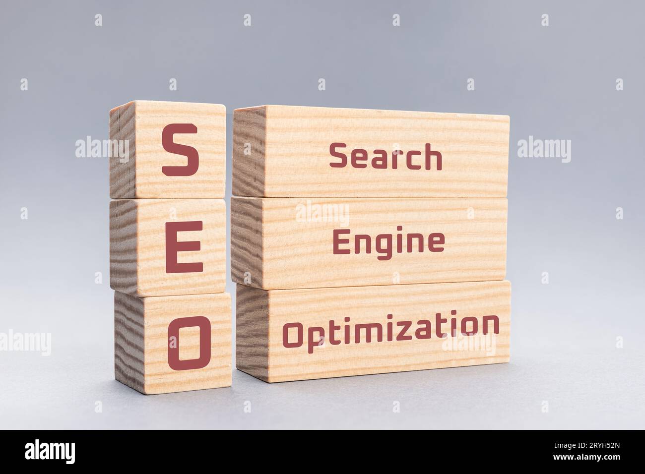 SEO Search Engine Optimization texte sur des blocs de bois sur fond gris Banque D'Images