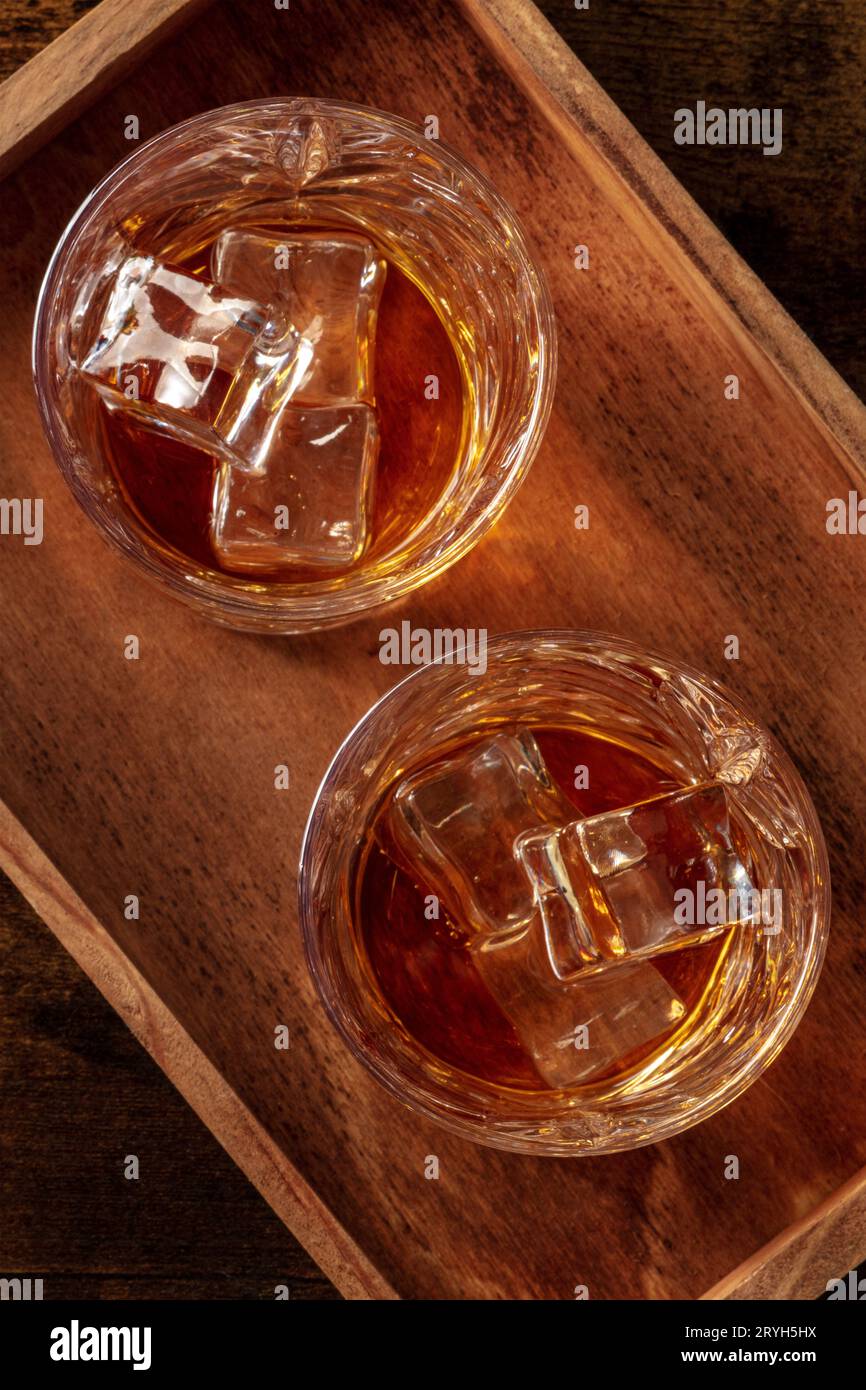 Whisky dans des verres avec de la glace. Whisky bourbon sur des rochers sur un fond sombre Banque D'Images