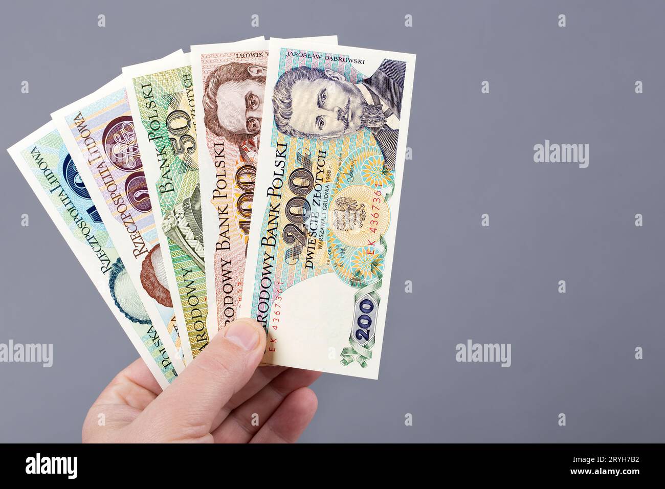 Vieux Zloty polonais dans la main sur un fond gris Banque D'Images