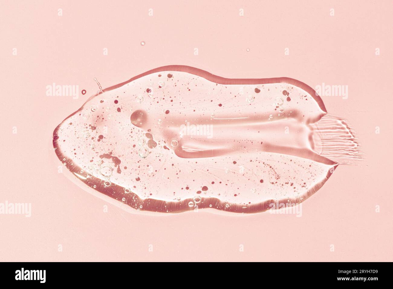 Frottis de gel liquide isolé sur fond rose. Lotion cosmétique de beauté, sérum de gelée pour le visage, nettoyant, gel douche ou shampooing Banque D'Images