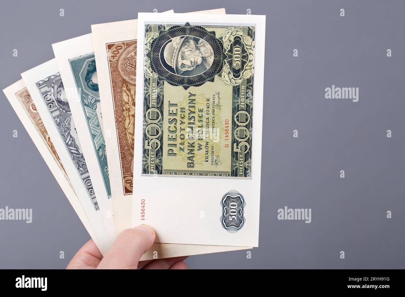 Vieux Zloty polonais dans la main sur un fond gris Banque D'Images