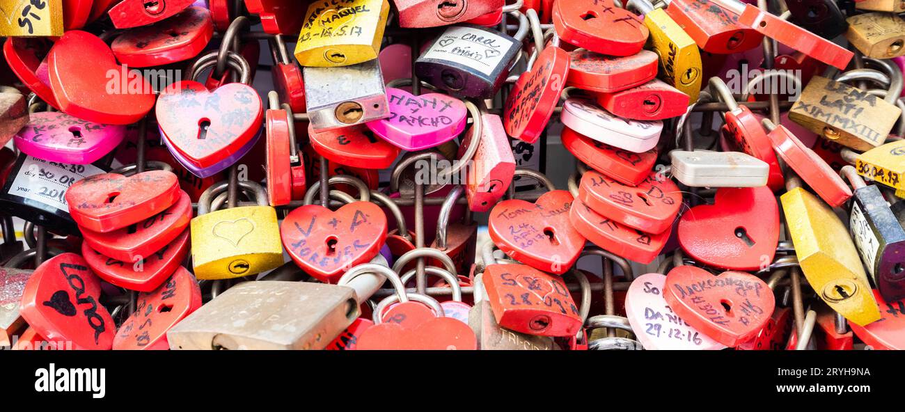 Vérone, Italie - juin 2022 : fond de serrures en forme de coeur sur un mur, symbole de l'amour pour toujours. Banque D'Images