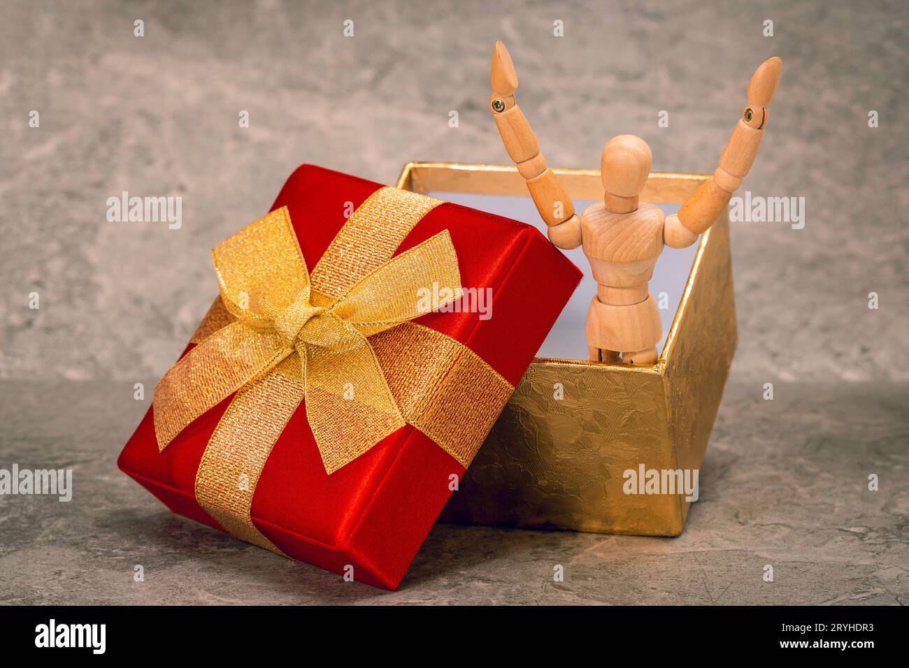 Joyeuse, mannequin en bois saute hors de la boîte cadeau Banque D'Images