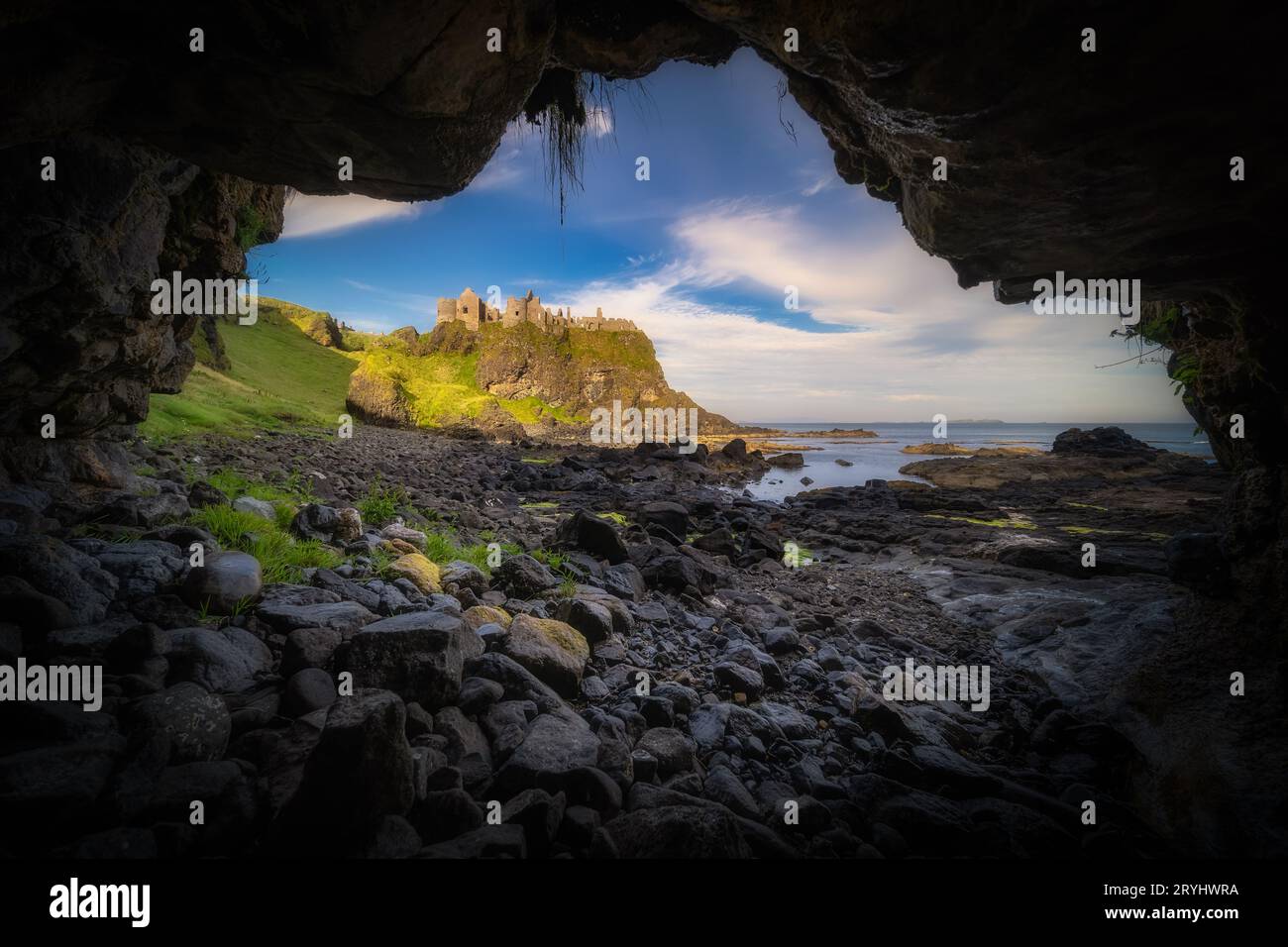 Château de Dunluce vu d'une petite grotte sur un rivage, Irlande du Nord Banque D'Images