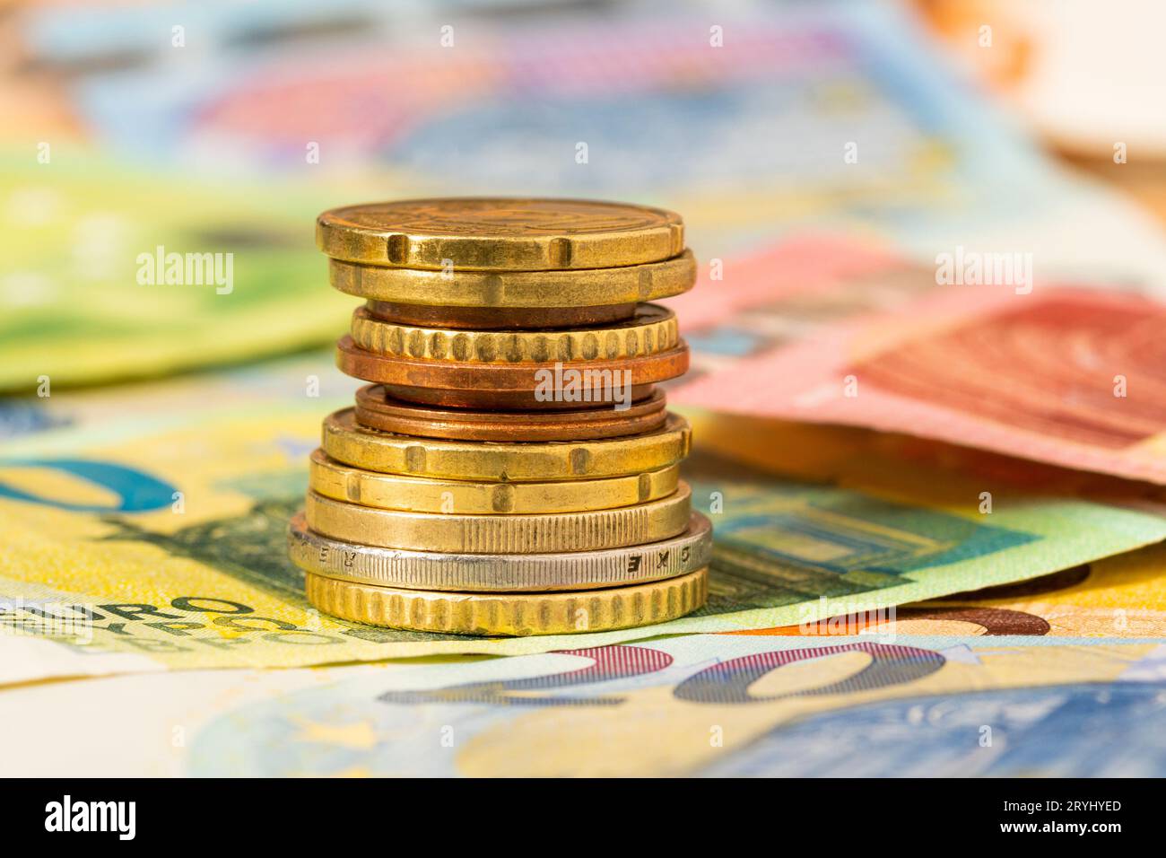 Les pièces en euros empilent sur les billets en euros Banque D'Images