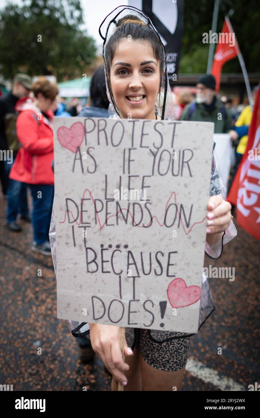 Manchester, Royaume-Uni. 01 octobre 2023. Un manifestant tient une pancarte avant le début de la marche. Des milliers de personnes défilent à travers la ville pour une manifestation nationale pendant la Conférence du Parti conservateur. Organisées par l'Assemblée des peuples et rejointes par les syndicats, les revendications comprennent la fin de la crise du coût de la vie et la défense du NHS. Crédit : Andy Barton/Alamy Live News Banque D'Images