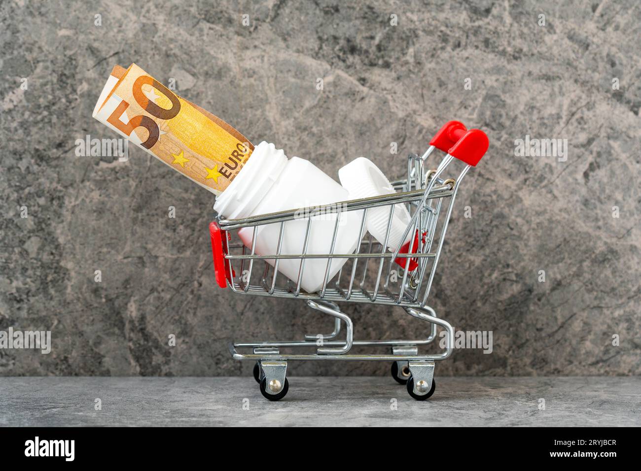 Bouteille de pilule et euro-argent dans un panier Banque D'Images