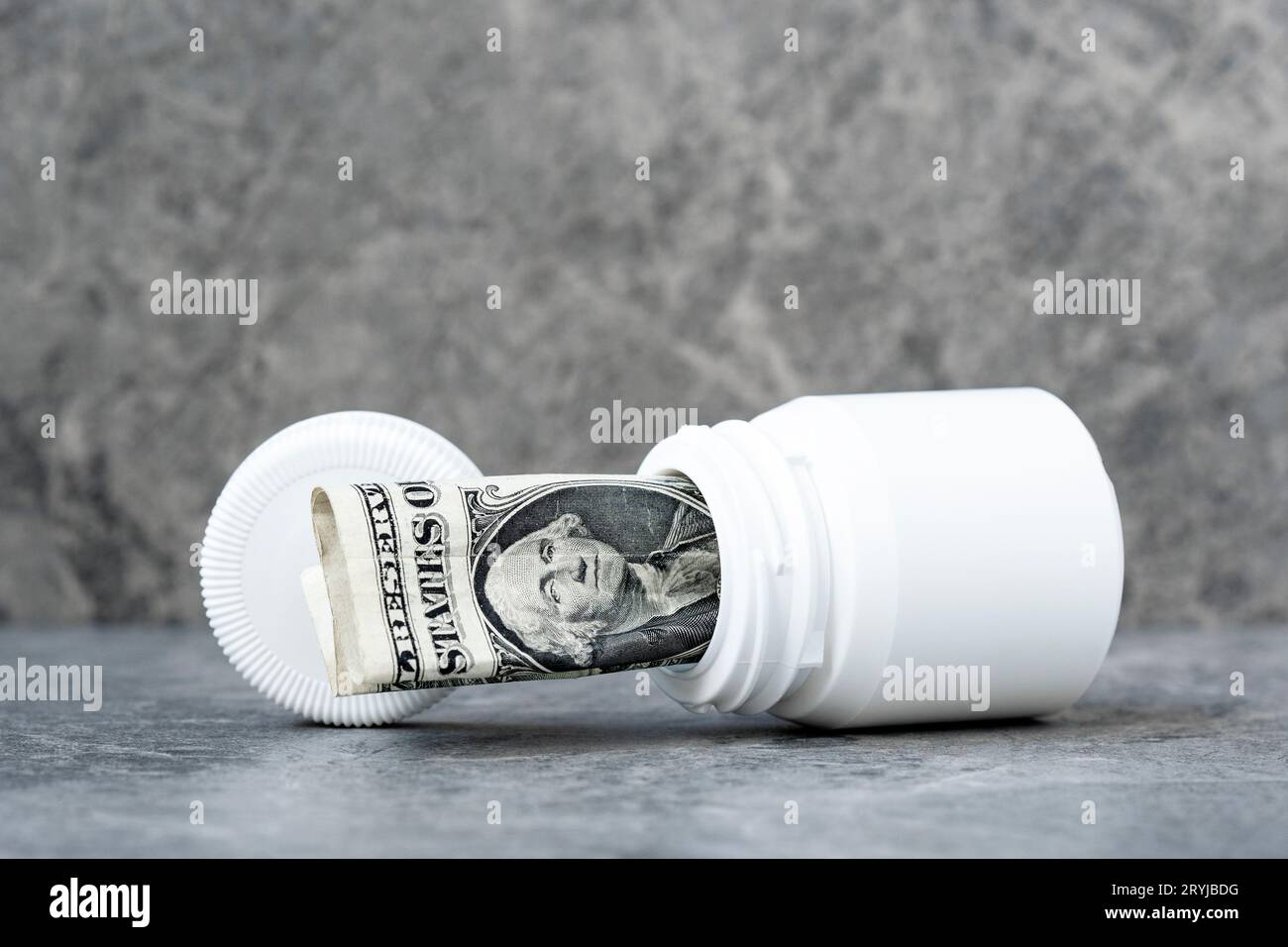 Un billet de banque d'un dollar roulé dans la bouteille de pilules Banque D'Images