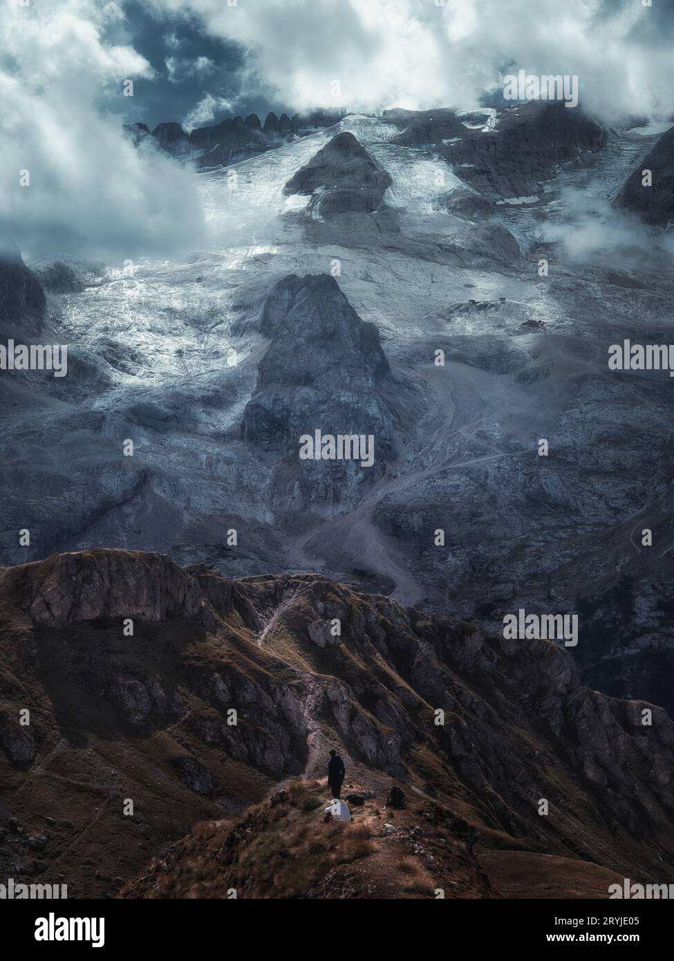 Vue spectaculaire sur la montagne de Marmolada, la plus haute montagne des Dolomites, avec des pentes couvertes de glacier et un randonneur solitaire, Italie. Banque D'Images