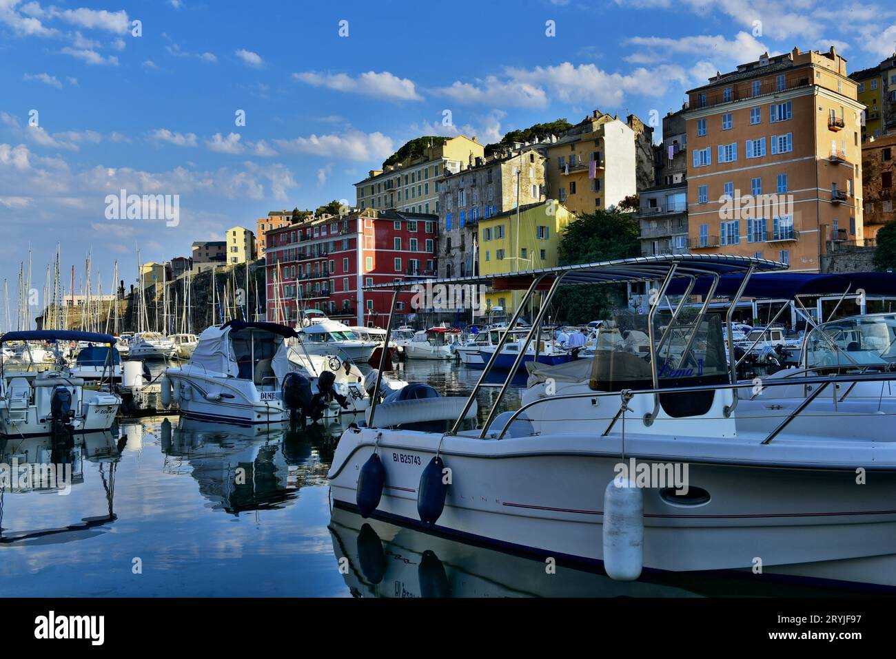 Des bâtiments coulants parsèment le front de mer dans le Vieux-Port de Bastia par une journée ensoleillée en juillet 2016, Corse, France Banque D'Images