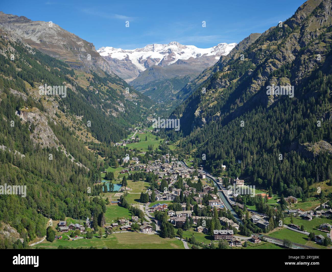 VUE AÉRIENNE. Village de Gressoney-Saint-Jean avec le mont Lyskamm (4533 mètres) au loin. Vallée d'Aoste, Italie. Banque D'Images