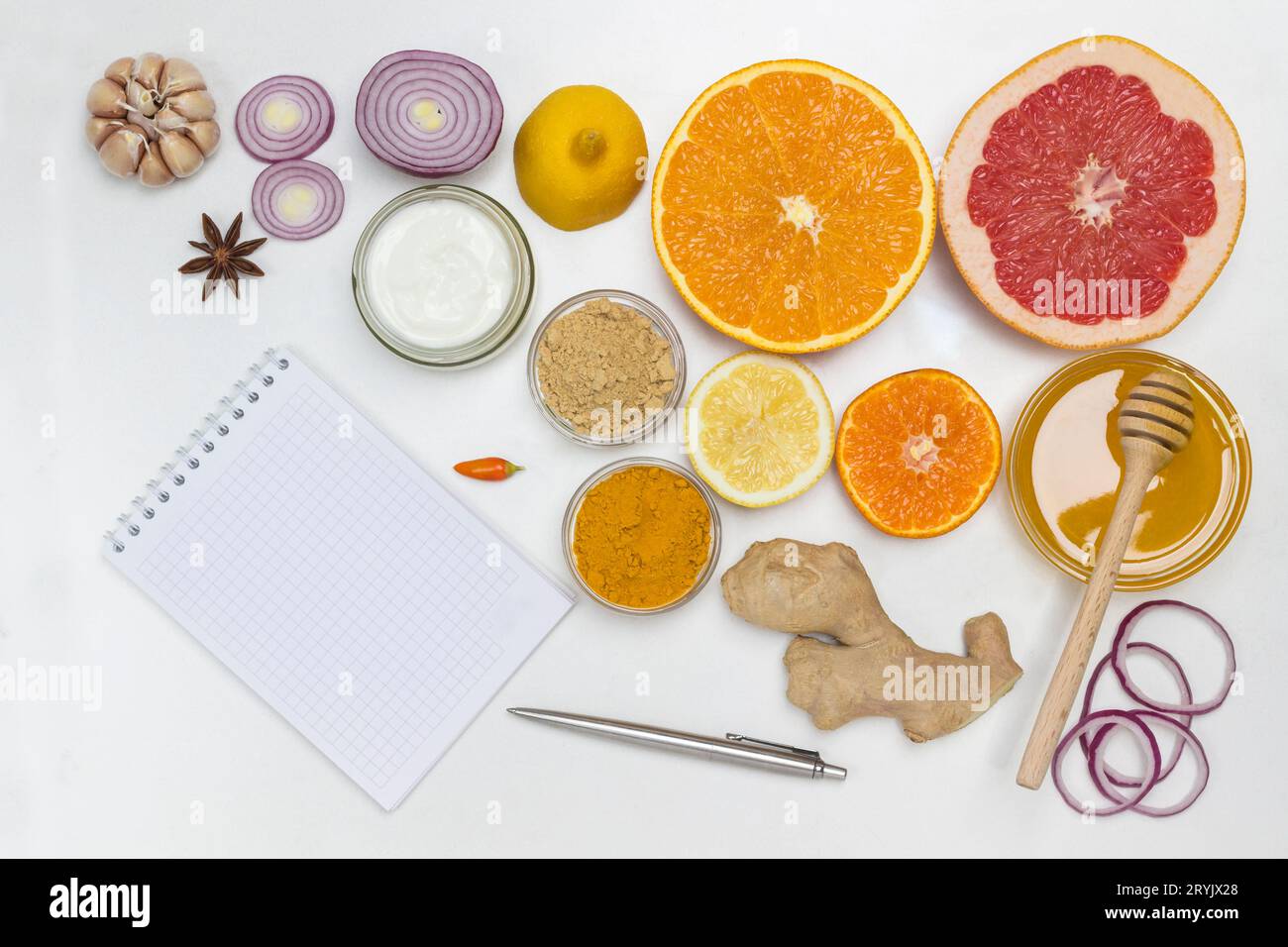 Aliment pour renforcer l'immunité et la protection contre les virus. Cahier et stylo sur la table. Remède naturel pour la prévention de la grippe. Fond blanc. Pose à plat Banque D'Images