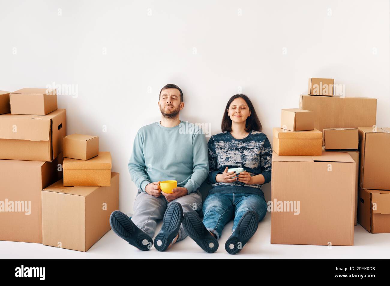 Heureux couple insouciant ayant une pause pendant le déménagement à la nouvelle maison et se détendre à l'étage profiter de leur appartement Banque D'Images