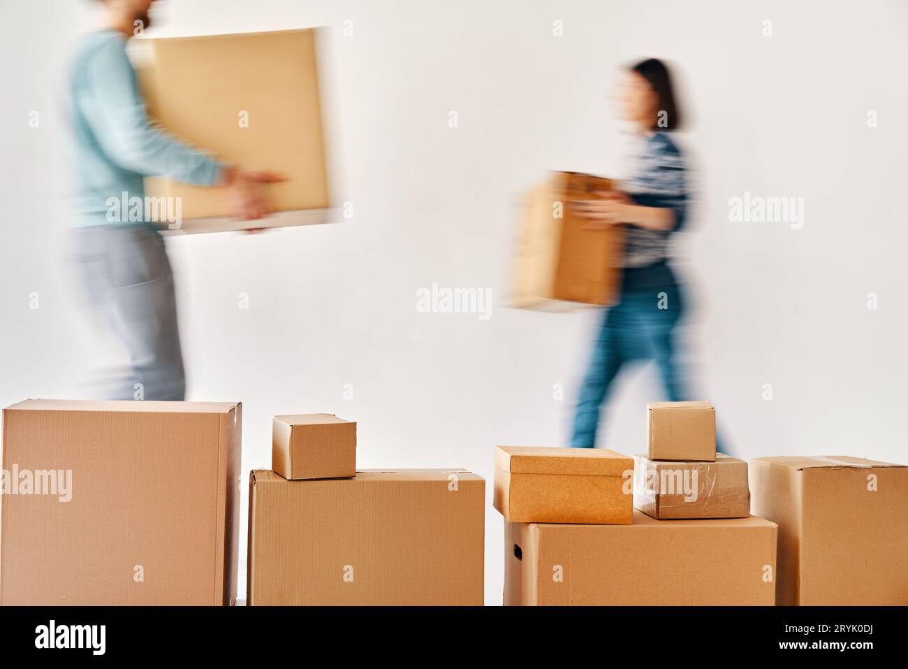 Mouvement flou du jeune couple portant des boîtes en carton déménageant dans une nouvelle maison Banque D'Images